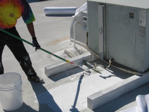 Applying an elastomeric coating on a flat roof near an air conditioner